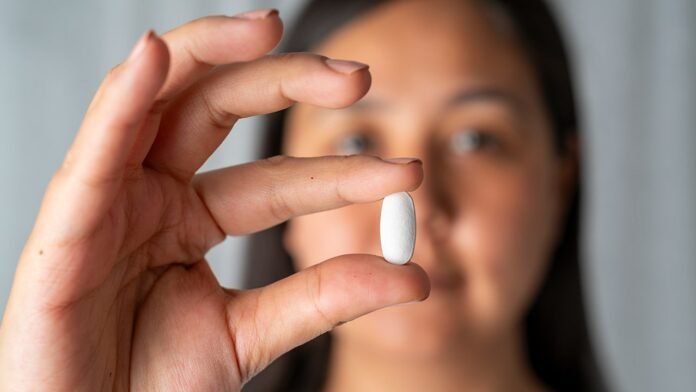 woman-holds-pill.jpg